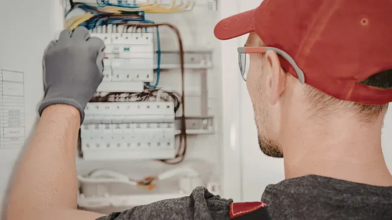 Açık elektrik panosu üzerinde sigorta arızası tespiti yapan profesyonel elektrikçi