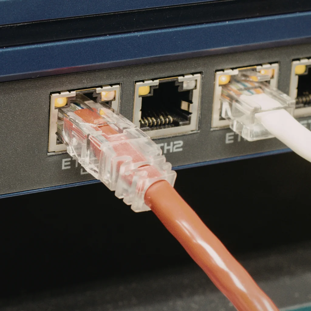 Bir network switch cihazına takılmış renkli RJ45 konnektörlü internet kabloları.